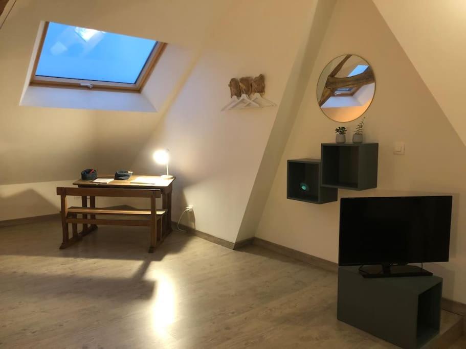 Televízia a/alebo spoločenská miestnosť v ubytovaní Maison sur la place du village d’Ourville en Caux