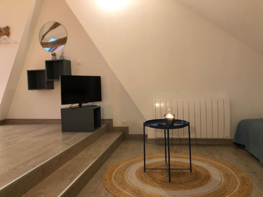 Televízia a/alebo spoločenská miestnosť v ubytovaní Maison sur la place du village d’Ourville en Caux