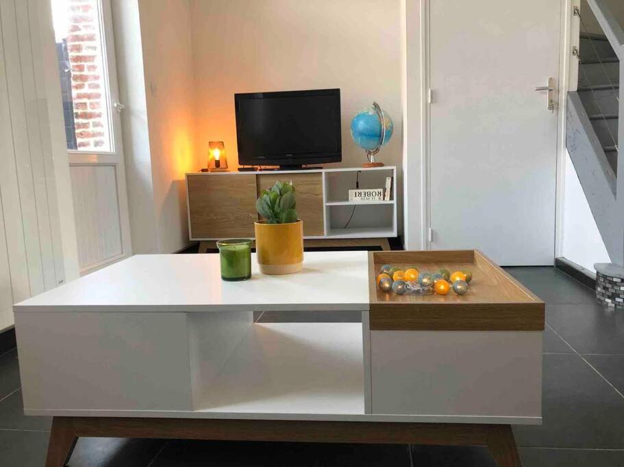 Televízia a/alebo spoločenská miestnosť v ubytovaní Maison sur la place du village d’Ourville en Caux