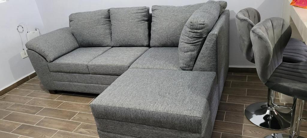 a gray couch in a living room next to a table at recamara en Departamento amueblado in Monterrey