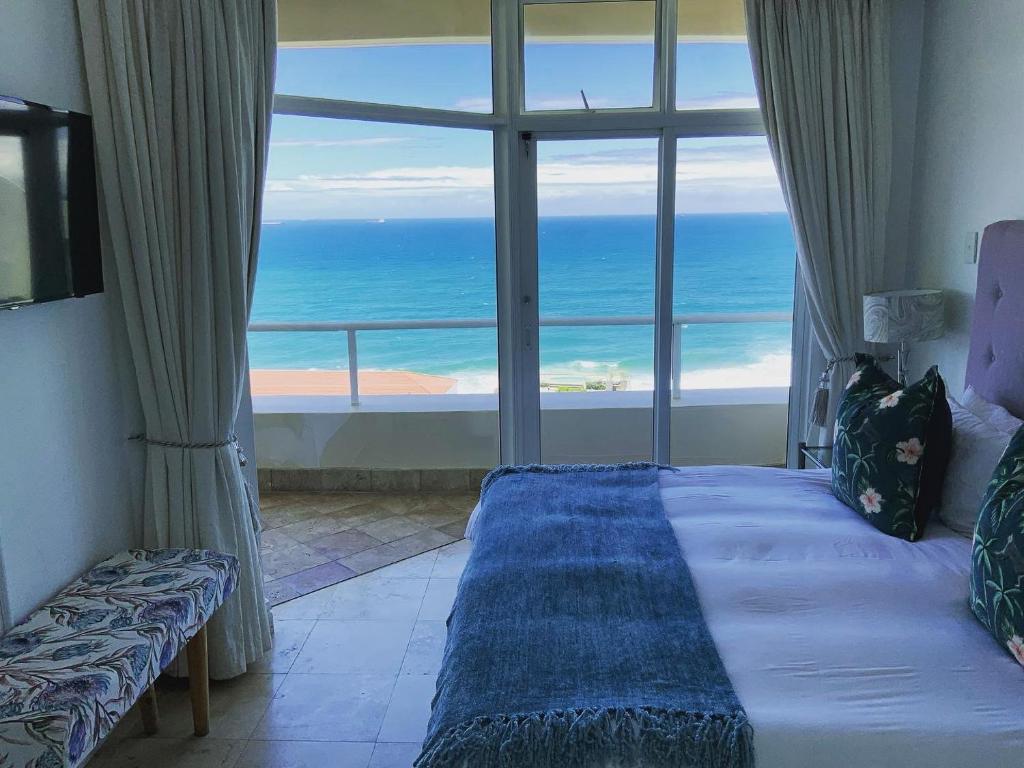 a bedroom with a bed with a view of the ocean at 702 Oyster Schelles in Durban