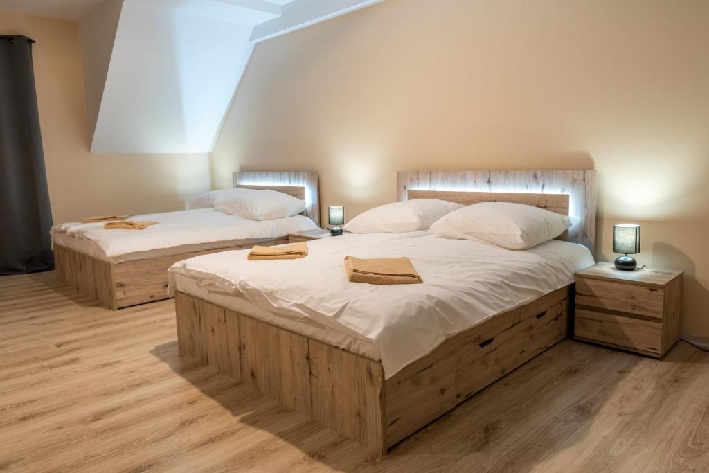 two beds in a bedroom with two lamps on them at Apartamenty Na Rozstaju in Kluszkowce