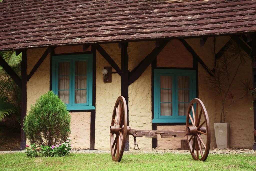 a house with two windows and a wagon in front of it at Sítio Urbano a apenas 1,5 km do centro in Blumenau