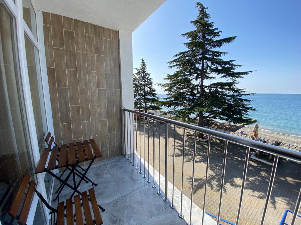 balkon z 2 krzesłami i widokiem na plażę w obiekcie Курортный отель Coocoorooza w Soczi
