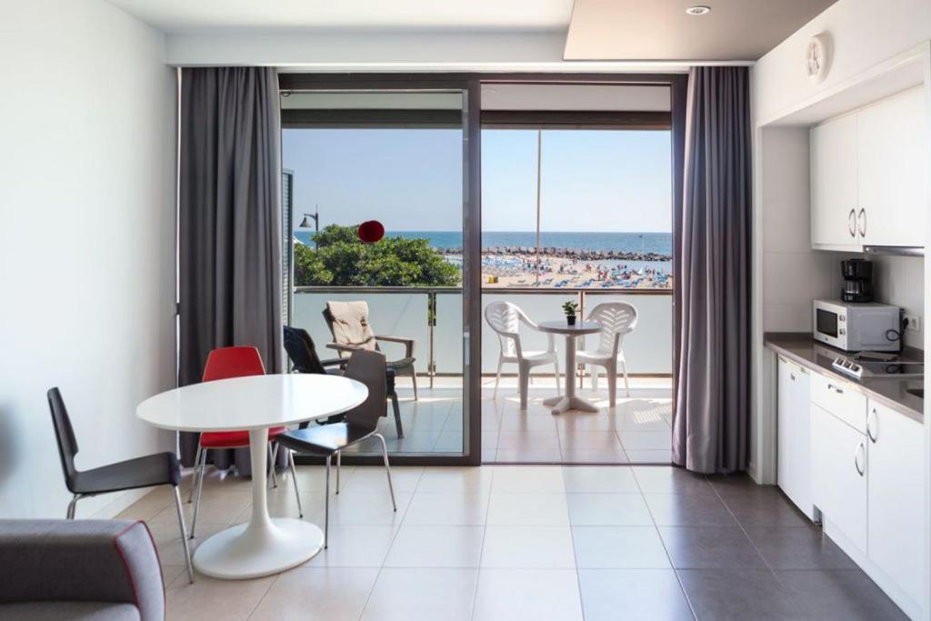 a kitchen and a living room with a table and chairs at RentOnTheBeach Studio 2 in Los Cristianos