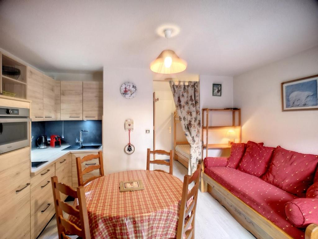 un salon avec un canapé rouge et une table dans l'établissement Les Menuires: 2 Pièces, 4 Pers, Pied des Pistes, Parking Gratuit - FR-1-178-100, aux Menuires