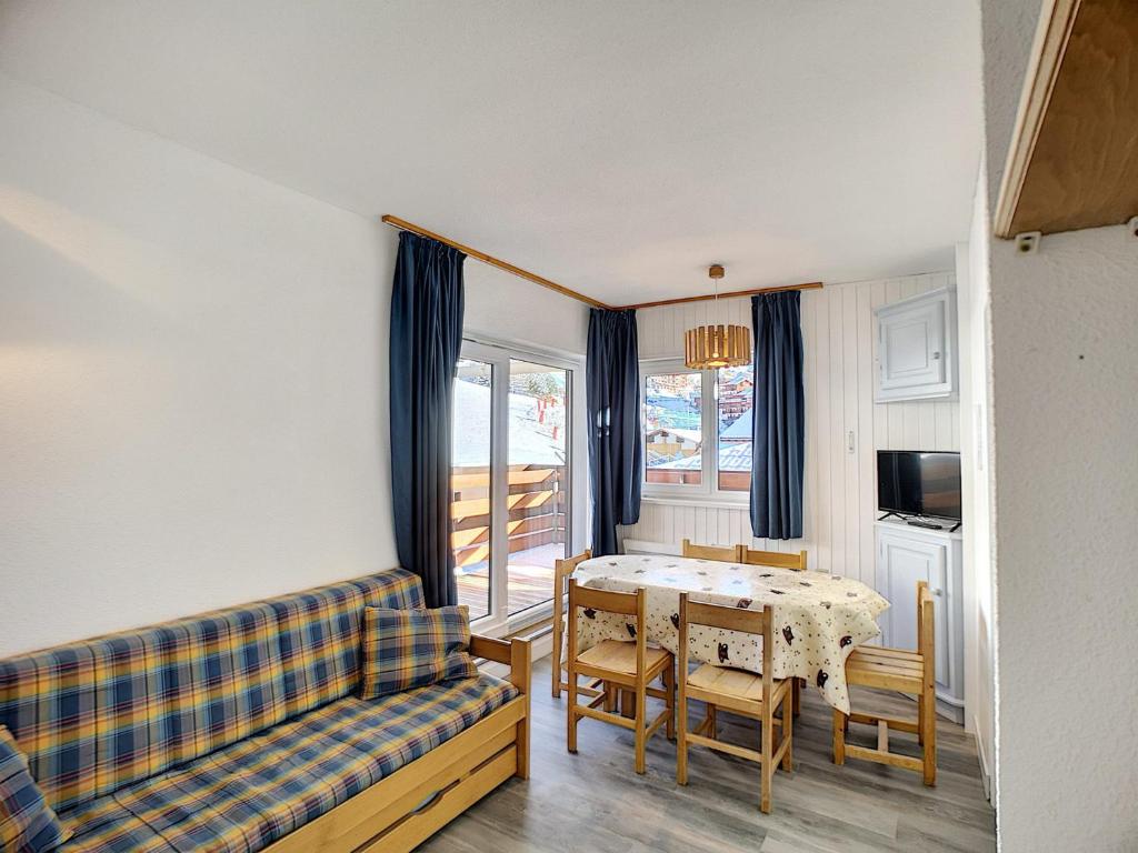 un salon avec une table et un canapé dans l'établissement 3 pièces 6 pers aux Bruyères - Animaux admis, parking et balcon - FR-1-178-104, aux Menuires