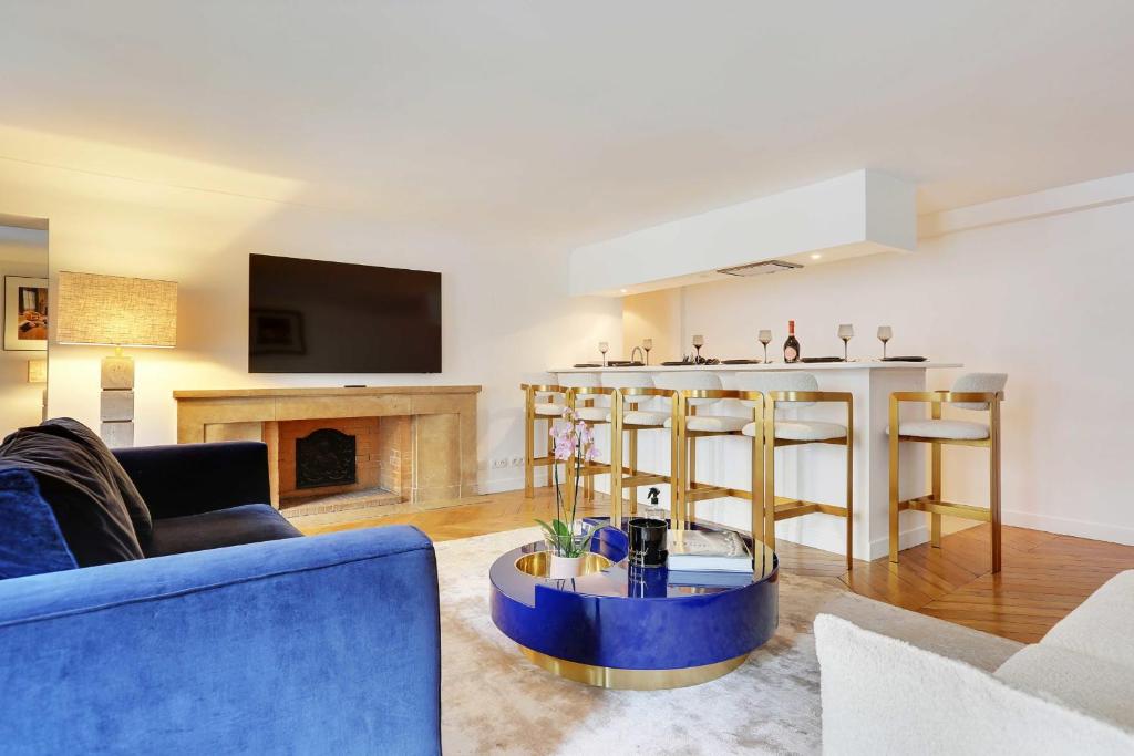uma sala de estar com um sofá azul e uma lareira em Amazing apartment 2BR4P avenue Montaigne Triangle d'Or em Paris