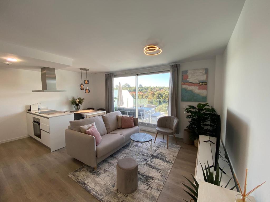 a living room with a couch and a kitchen at Zen Apartment Estepona in Estepona