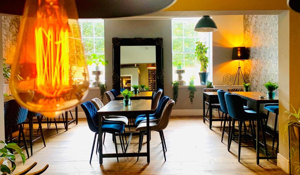 a dining room with tables and chairs and a mirror at The Capon Tree Town House in Jedburgh