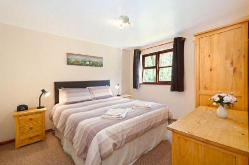 a bedroom with a large bed and a window at CHESNUT - 2 Bedroom Lodge in Kingsnorth