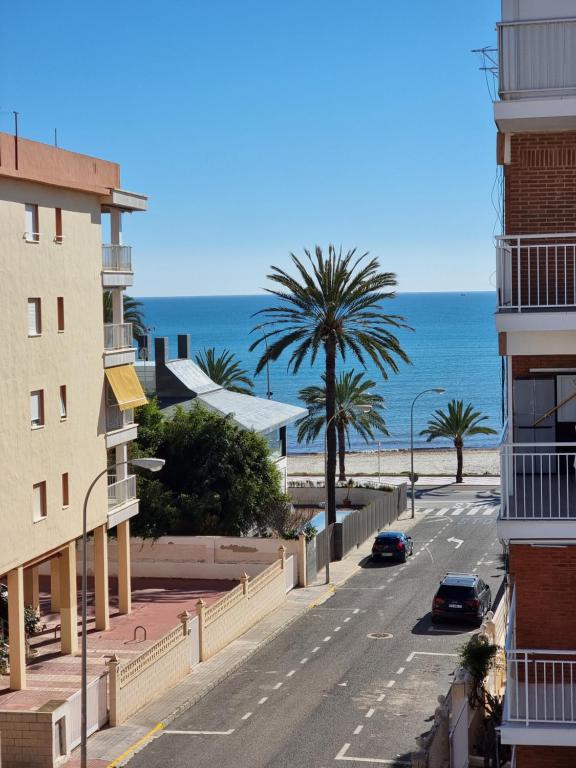 eine Straße mit Gebäuden und dem Meer im Hintergrund in der Unterkunft Bolivia Sea View Santa Pola in Santa Pola