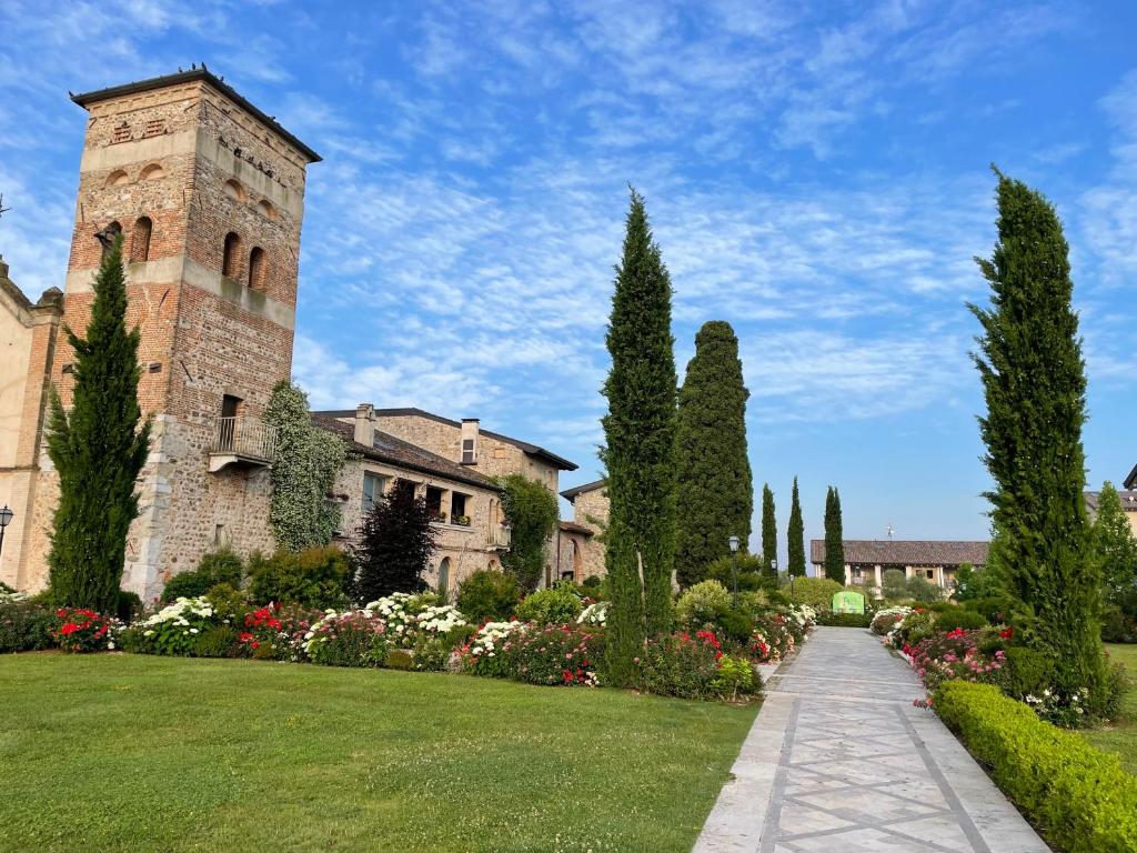 a building with a clock tower and a garden at Appartamento Stella in Pozzolengo