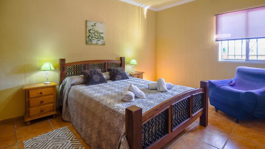 sypialnia z łóżkiem i niebieskim krzesłem w obiekcie Villa Nerja Views - by Casitas Select w mieście Nerja