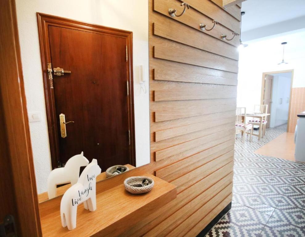 una habitación con 2 sillas blancas y una puerta en RentalSevilla Cool flat in Triana with parking., en Sevilla