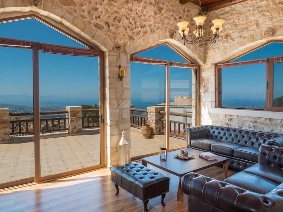 Villa Malaxa Private Luxury with Amazing View في Maláxa: غرفة معيشة مع أريكة وطاولة