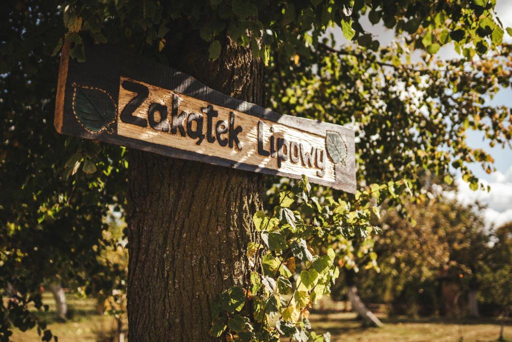 a sign on the side of a tree at Zakątek Lipowy - Turystyka Stulichy in Węgorzewo