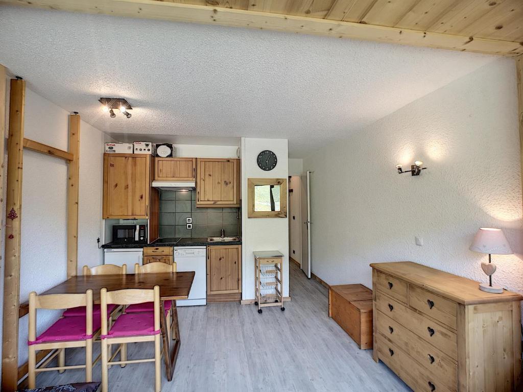 une cuisine avec des armoires en bois et une table et des chaises dans l'établissement Bel Apt 2 Pièces rénové 5 pers 30m² Expo SO, Pistes & Commerces Proches, Wifi Inclus - FR-1-178-70, aux Menuires