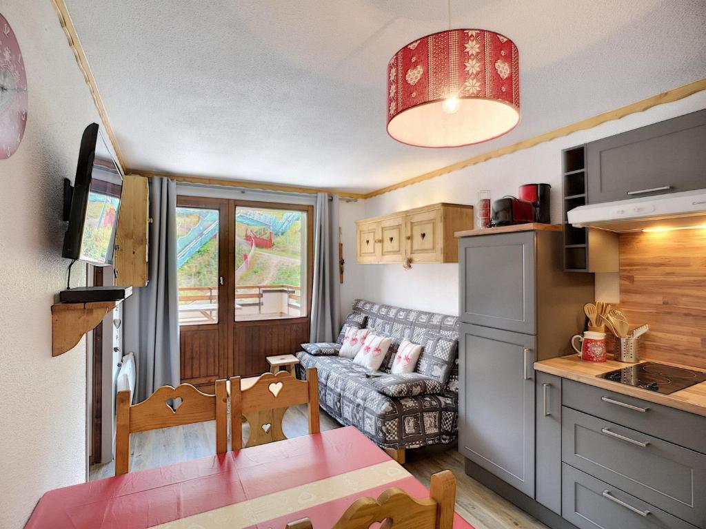 Il comprend une petite cuisine et un salon avec un canapé. dans l'établissement Appartement 2 Pièces + Coin Montagne, Terrasse, 5 Pers, Skis aux Pieds - Les Bruyères, Les Menuires - FR-1-178-88, aux Menuires