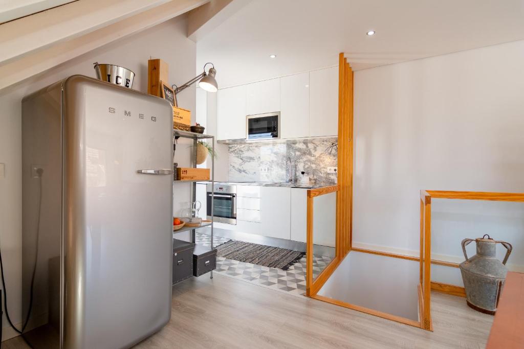 a kitchen with a refrigerator in the middle of a room at Casa Atelier in Setúbal