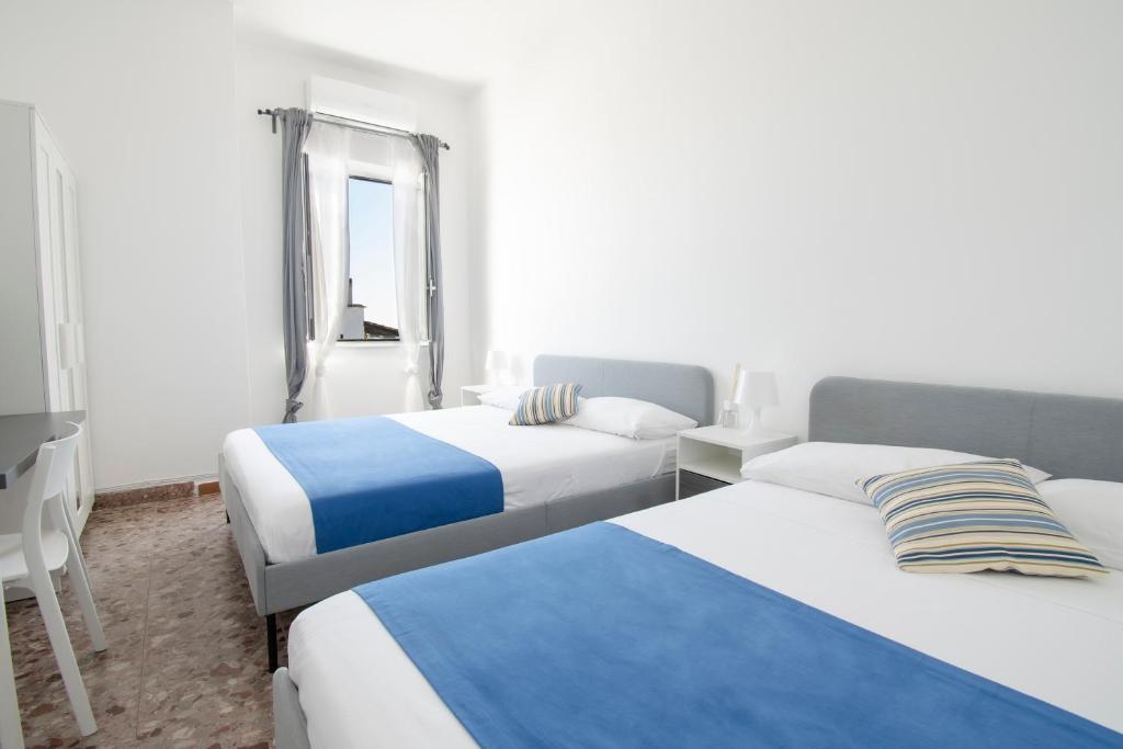 um quarto de hotel com duas camas e uma janela em Rusticano B&B em Ischia