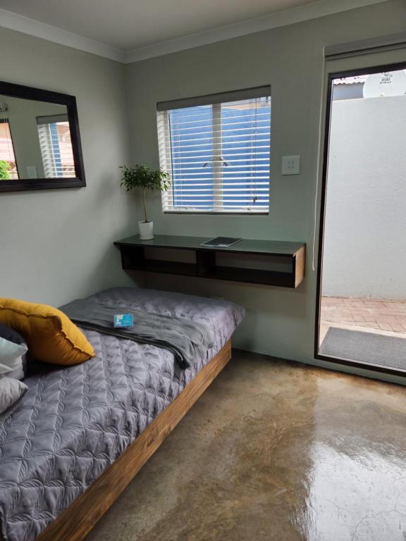 a bedroom with a bed and a large window at Die Stoor in Upington