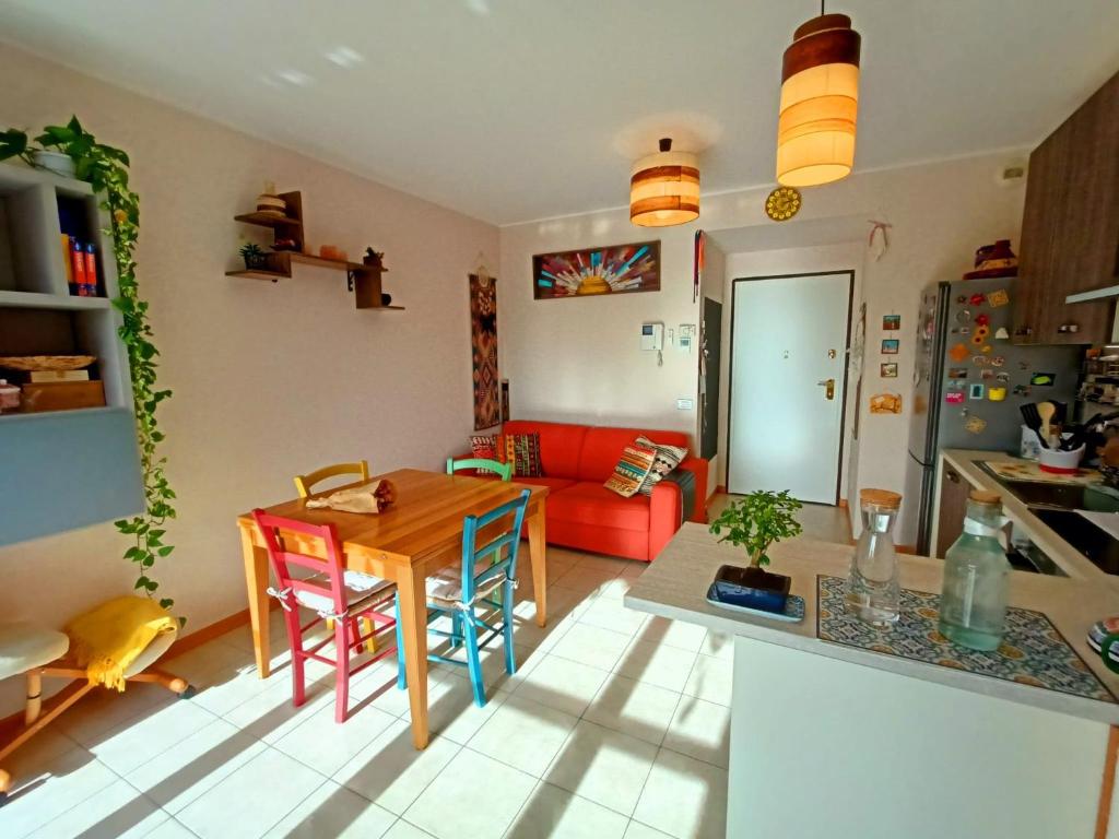 sala de estar con mesa y sofá rojo en Relaxing apartment near Milan, en Vimodrone