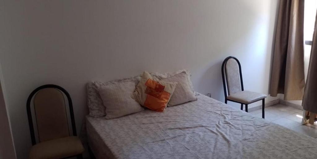 1 dormitorio con 1 cama con 2 almohadas y 1 silla en DEPARTAMENTO 1 en Córdoba