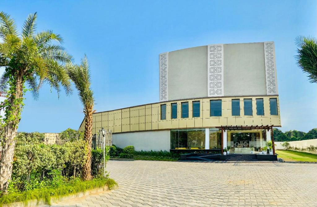 a building with a palm tree in front of it at Sterling Mantra Haridwar in Haridwār
