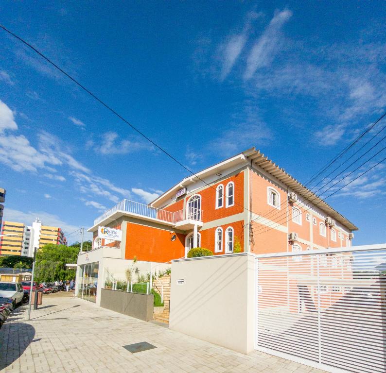 a large orange house with a white fence at Pousada Recanto das Caldas in Caldas Novas