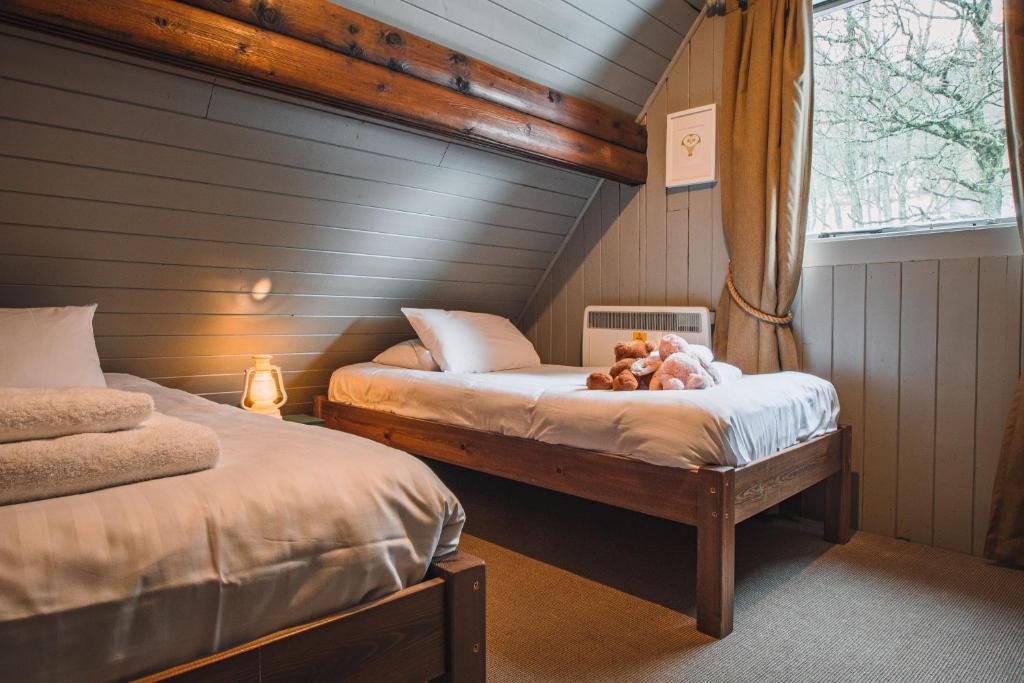 a bedroom with two beds with a teddy bear on it at Crieff Hydro Self Catering in Crieff