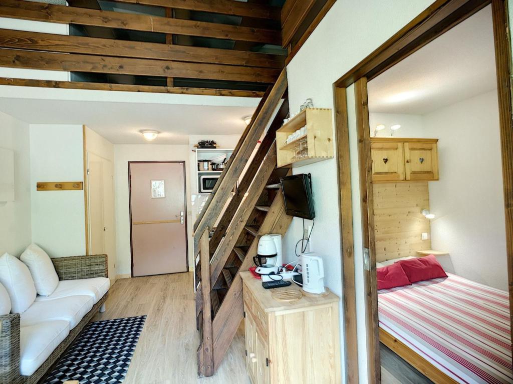 une petite maison avec un escalier et un lit dans l'établissement 2 Pièces + mezzanine 6 pers, ski aux pieds, wifi, parking - FR-1-178-15, aux Menuires