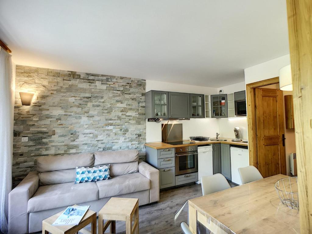 un salon avec un canapé et une cuisine dans l'établissement Les Menuires: 2P+Coin Montagne, 4 pers, Balcon, Parking gratuit, Pied Des Pistes - FR-1-178-30, aux Menuires