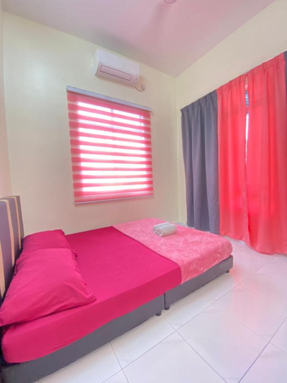 a bedroom with a bed with pink sheets and a window at Hana Homestay in Pendang