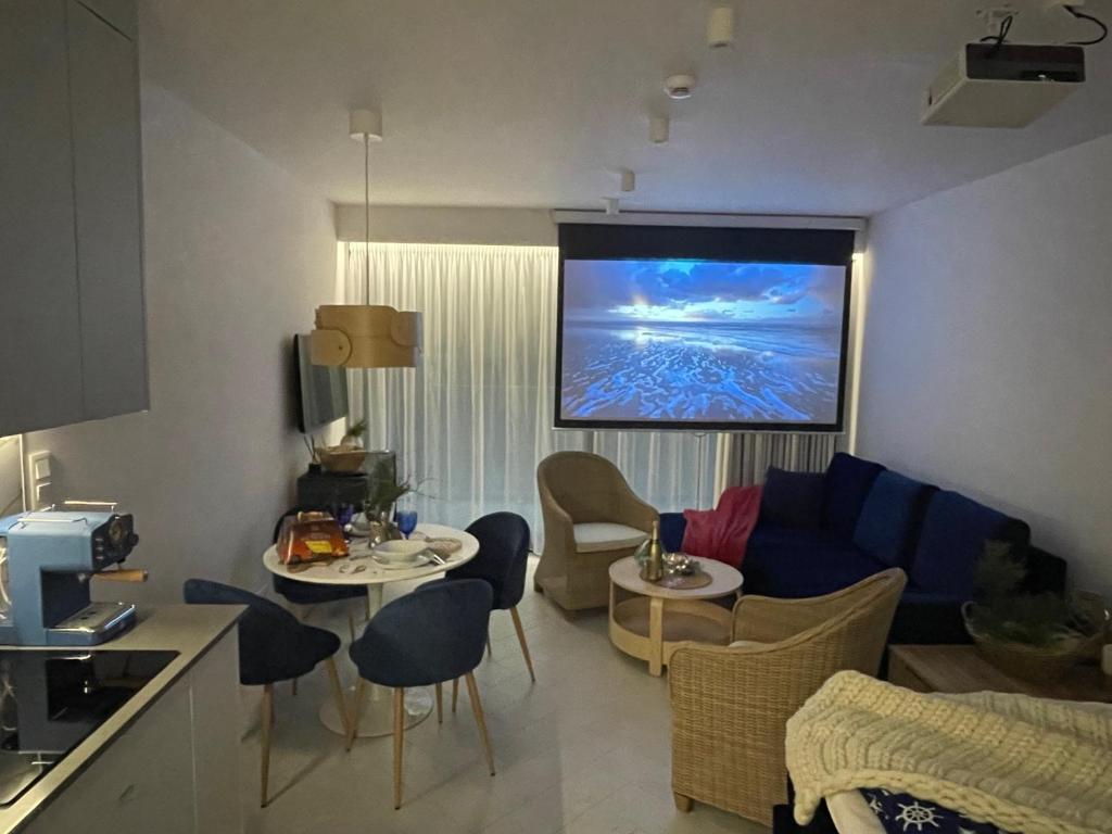 Apartament Sea & Lake z basenem Silence Mielno في ميلنو: غرفة معيشة مع تلفزيون على الحائط