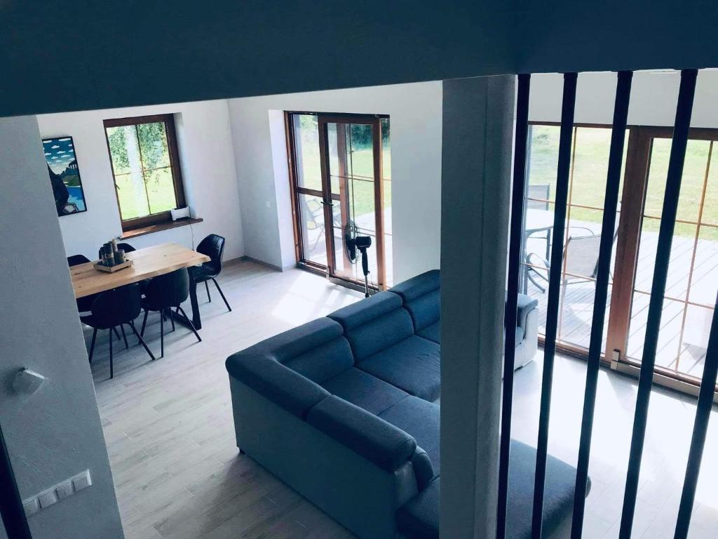 ein Wohnzimmer mit einem blauen Sofa und einem Tisch in der Unterkunft Seaside home Pape in Pape