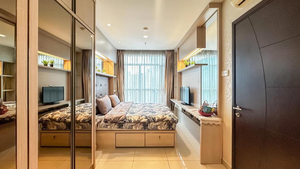 a bedroom with a bed with a glass wall at 2 Bedroom apartment on Central Park Mall in Jakarta