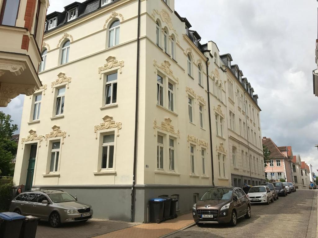 a white building with cars parked in front of it at FeWo Taubenstern in Schwerin