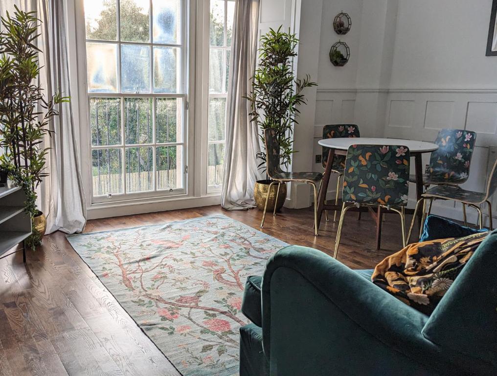 a living room with a couch and a table and chairs at Slateford House 1770 Luxury Aparthotel by The House of Danu in Edinburgh