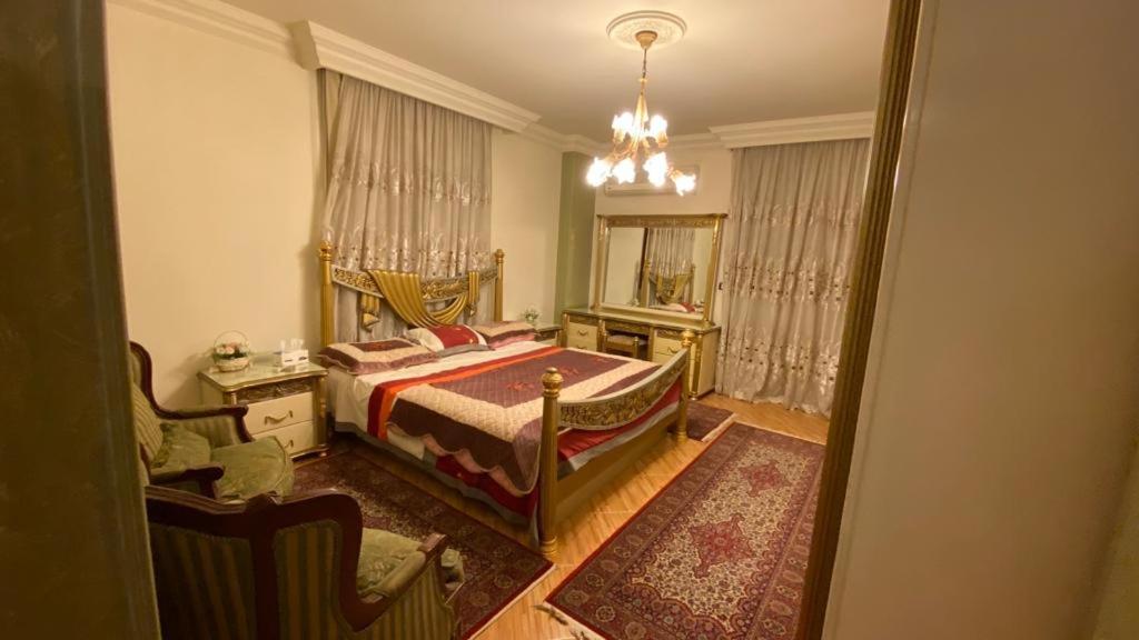 1 dormitorio con cama y lámpara de araña en مدينه 6 اكتوبر حدائق الفردوس الامن العام فيلا ٢٤٧ شارع ٨ en Madīnat Sittah Uktūbar