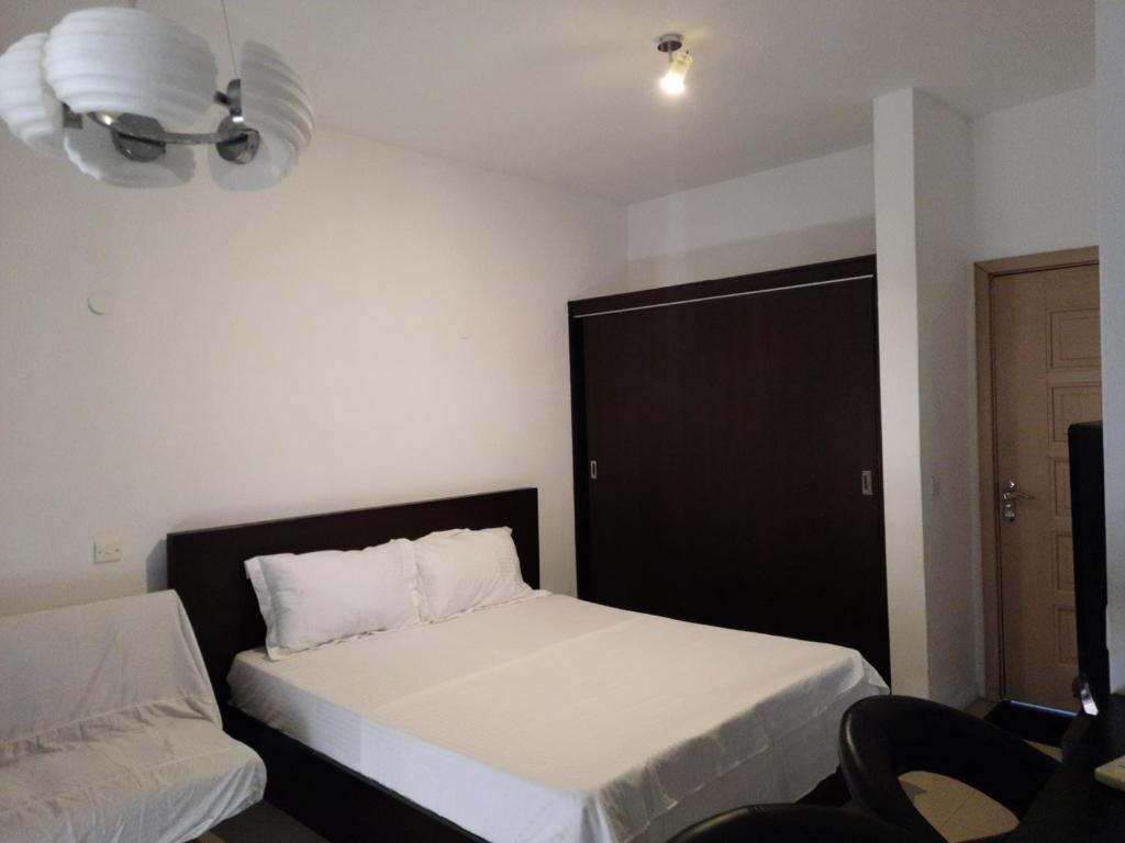 1 dormitorio con 2 camas y puerta negra en Ocean Drive Studio, next to the Beach en Grand Baie