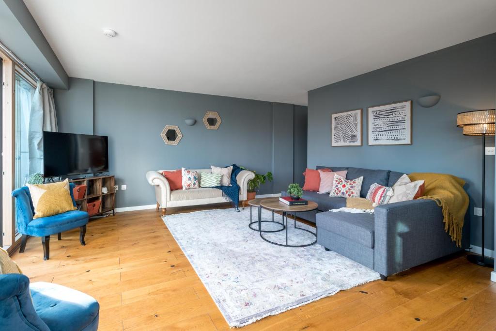 a living room with a couch and a table at 2 bedroom apartment with park views Shoreditch in London