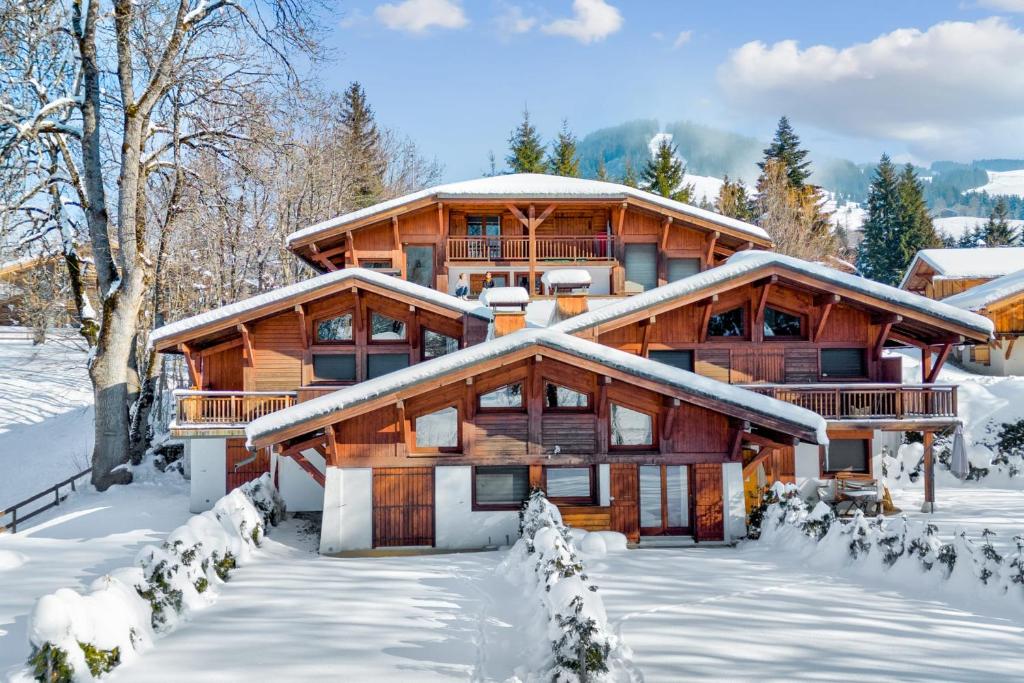 a log home in the snow with snow covered trees at Beautiful suite with garden at the foot of the slopes - Welkeys in Megève