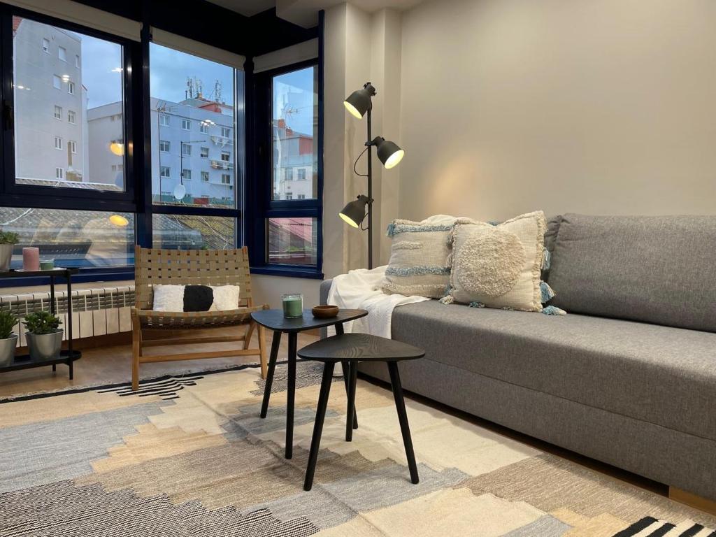 ein Wohnzimmer mit einem Sofa und einem Tisch in der Unterkunft Housingcoruña ORILLAMAR in A Coruña