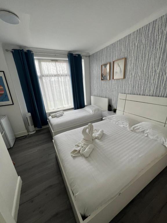 um quarto com duas camas com um ursinho de peluche em Diana Hotel em Londres