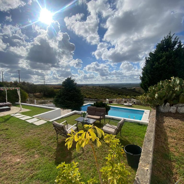 a backyard with a swimming pool and a lawn with two chairs at Venus House in Lamas