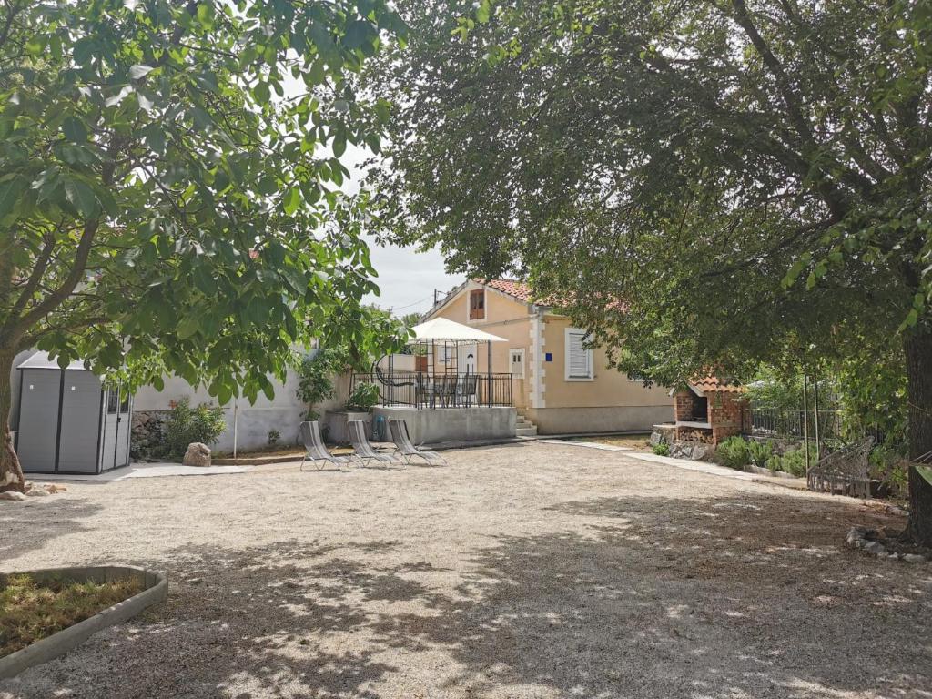a yard with chairs and a house at Holiday House Rasopasno in Rasopasno
