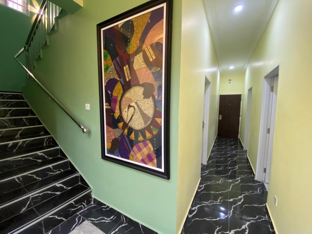 a painting on the wall of a hallway with stairs at C7 Hazelwood Residence & Suites in Abuja