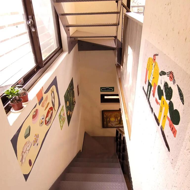 a staircase in a house with colorful stickers on the walls at Taipei Jinguashi Cloud Mountain Homestay B&amp;B in Jiufen