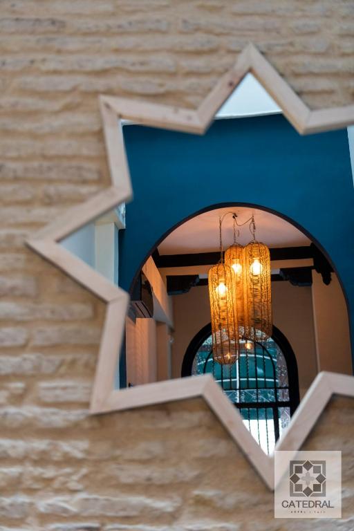 a chandelier hangs from a blue wall at Casa Catedral in Seville
